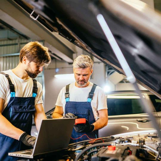Auto mechanics using Power Start power supplies to repair car