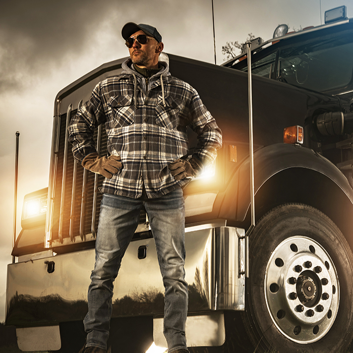 truck driver standing in front of truck he started with powerstart jumpstarter